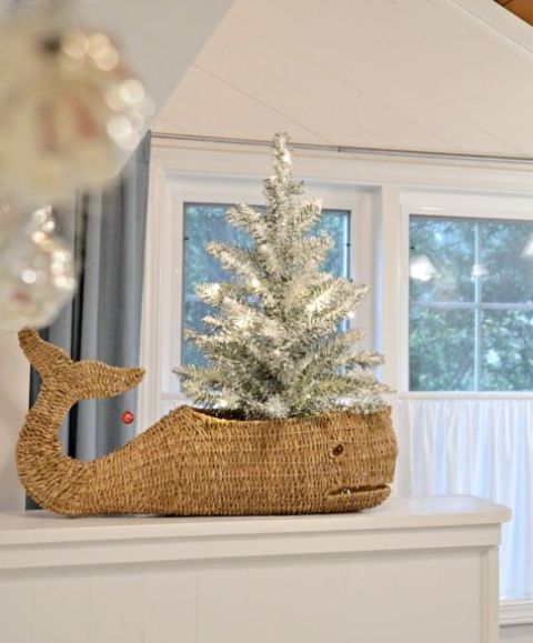 a whale basket with a small flocked Christmas tree with lights is a lovely beach or coastal Christmas decoration
