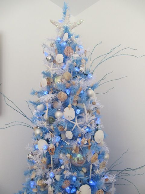 a white Christmas tree with bold blue bottle cleaners, seashells, starfish, twigs, corals and blue lights for a coastal Christmas space