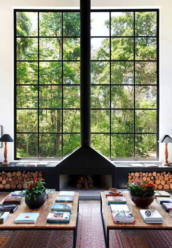 an open fireplace by the window and a windowsill bench with open storage for firewood perfectly match this modern interior