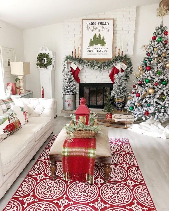 bright and fun Christmas decor with a flocked tree with gold, green and red ornaments, plaid pillows and a runner, red stockings, a flocked garland and flocked mini trees