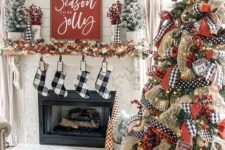 farmhouse Christmas decor with plaid stockings, a fir garland with lights, flocked mini trees and a large on with lights and printed ribbons