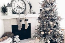 gorgeous monochromatic Christmas decor with a flocked Christmas tree with gold, black and white ornaments, knit stockings, mini trees and chunky blankets