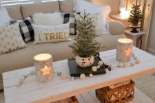 lovely holiday decor with star candleholders, white and silver bell garland, a couple of mini trees and a flocked Christmas wreath