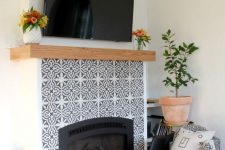 mosaic patterned grey and white tiles plus a wooden mantel look amazing and bring elegance to the rustic space
