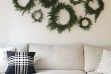 simple and natural evergreen and greenery Christmas wreaths hanging on a stick for a neutral festive touch to the space