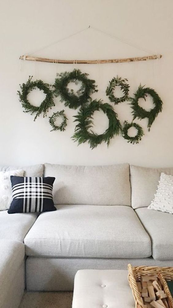 simple and natural evergreen and greenery Christmas wreaths hanging on a stick for a neutral festive touch to the space