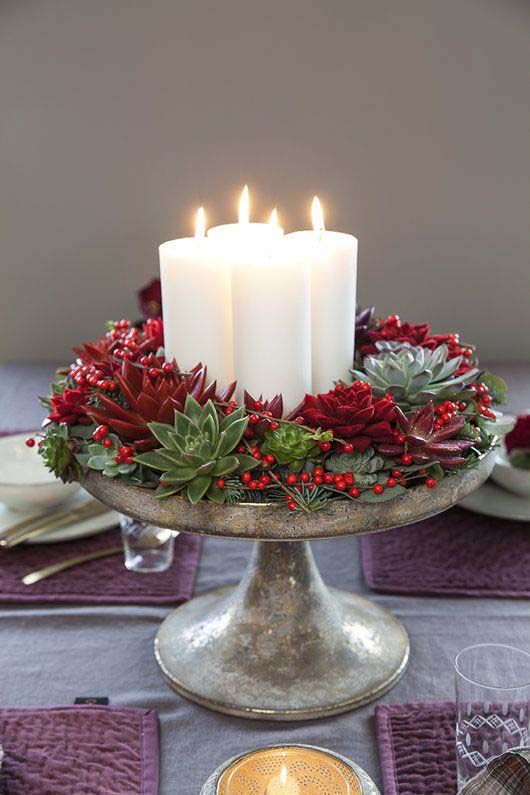 a Christmas centerpiece of a vintage bowl, succulents and evergreens, red succulents, berries and pillar candles is wow