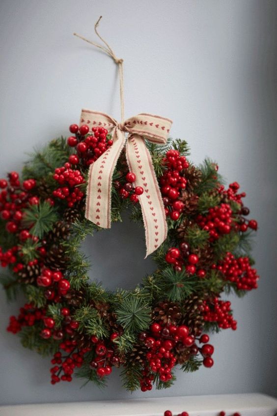 a beautiful Christmas wreath of evergreens, pinecones, cranberries and holly berries and a printed bow is amazing