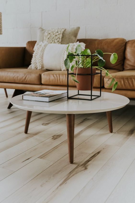 a beautiful and timeless mid-century modern coffee table with a white round tabletop and rich-stained tapered legs is a gorgeous idea to rock