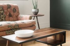 a beautiful mid-century modern coffee table with a curved tabletop that makes an open storage compartment and with black edges