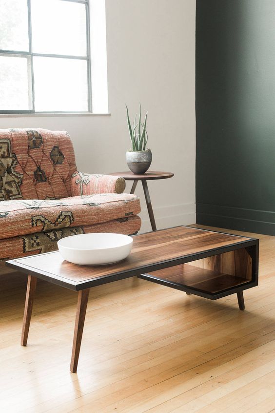 a beautiful mid-century modern coffee table with a curved tabletop that makes an open storage compartment and with black edges