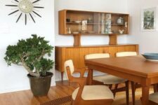 a bold mid-century modern space done in earthy tones, with stained furniture, a statement rug and a statement plant in the corner