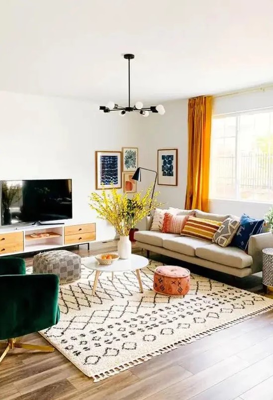 a bright mid-century modern living room with a comfy sofa, a green chair, a TV unit, printed textiles and a bright gallery wall