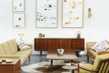 a bright mid-century modern living room with mustard colored furniture and abstract paintings