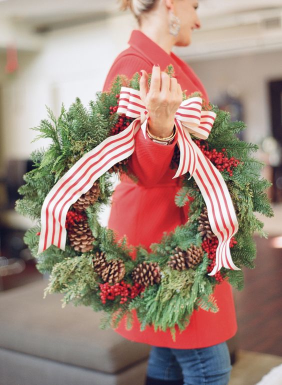 a classic Christmas wreath of evergreens, pinecones and cranberries plus a striped ribbon bow is a cool decoration to rock