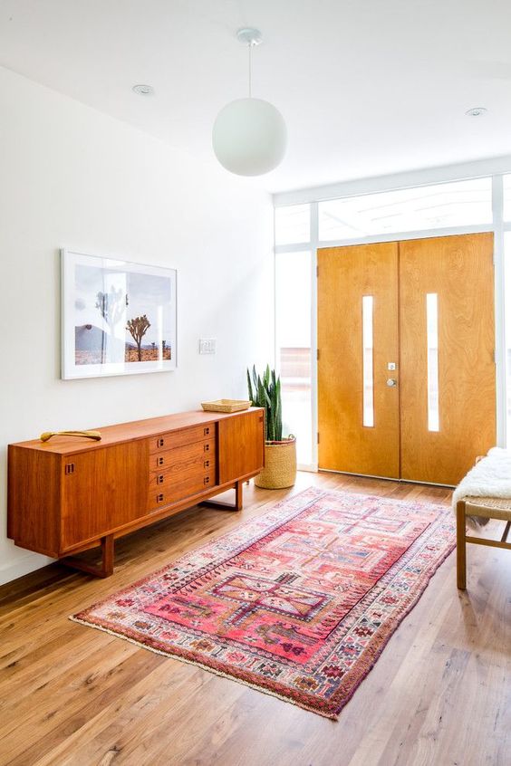 a cool rich-stained mid-century modern sideboard with drawers and doors, with small metal handles and on frame legs