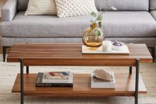 a cool wooden coffee table with two tabletops – a slab and a sleek one and tall black legs is a stylish and functional idea to rock