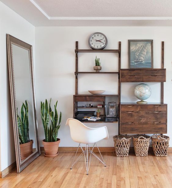 a dark stained wall unit with open shelves, a bureau with a desk and drawers next to it is great for a mid-century modern space