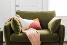a green mid-century modern chair with pillows and tall metal legs, with a woven blanket and a printed pillow is a cool and cozy idea