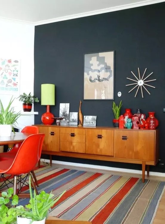 a light-stained mid-century modern cabinet with doors and black handles is a stylish idea for this bold dining room