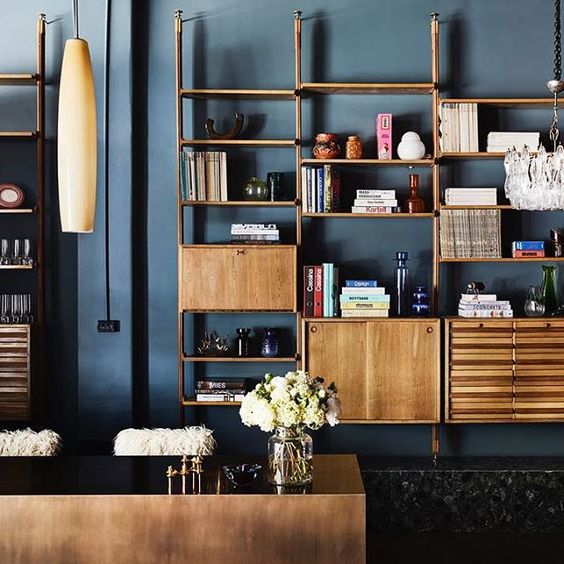 a light stained storage unit with cabinets, drawers, open shelves placed symmetrically in the upper part