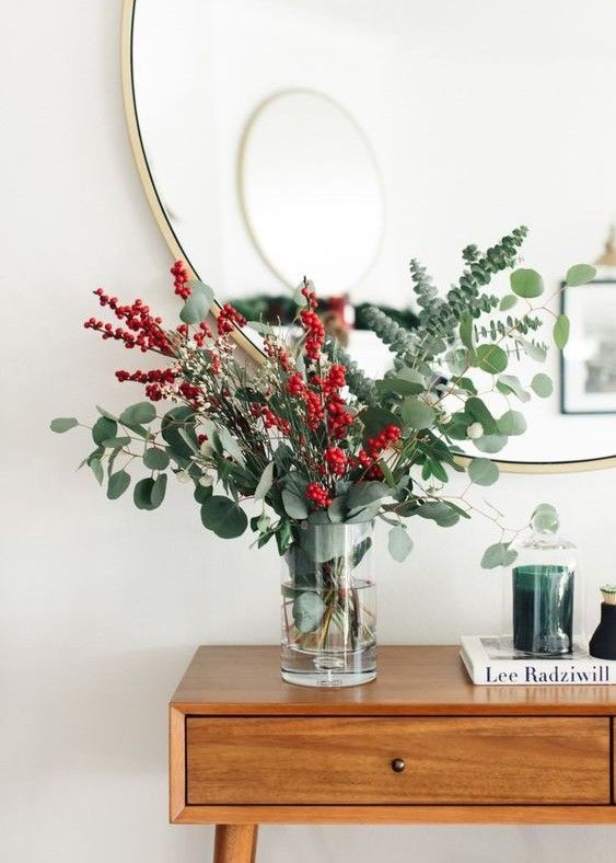 a lovely Christmassy arrangement with eucalyptus, holly berries and cranberries is a cool centerpiece, too