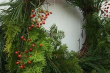 a lush Christmas wreath of evergreens and ferns, some berries on top is a gorgeous decoration for a front door