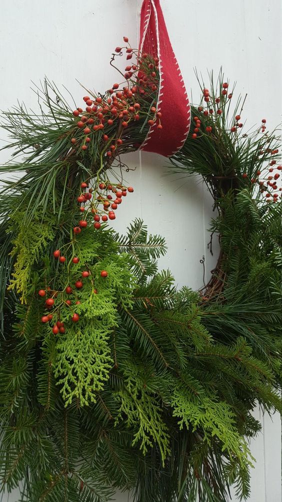 a lush Christmas wreath of evergreens and ferns, some berries on top is a gorgeous decoration for a front door