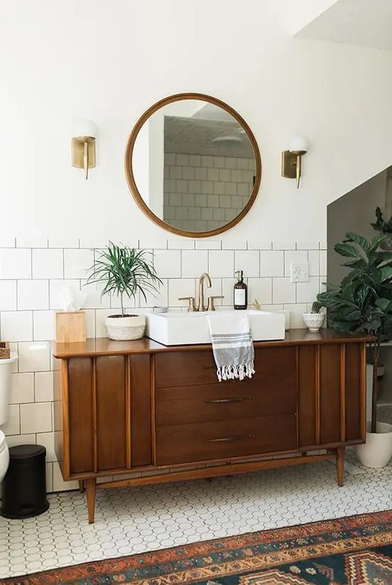 a mid-century modern bathroom finished off with a stained cabinet that is a vanity that provides storage space