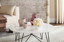 a mid-century modern coffee table with a white round tabletop and black geometric legs is a great idea to rock