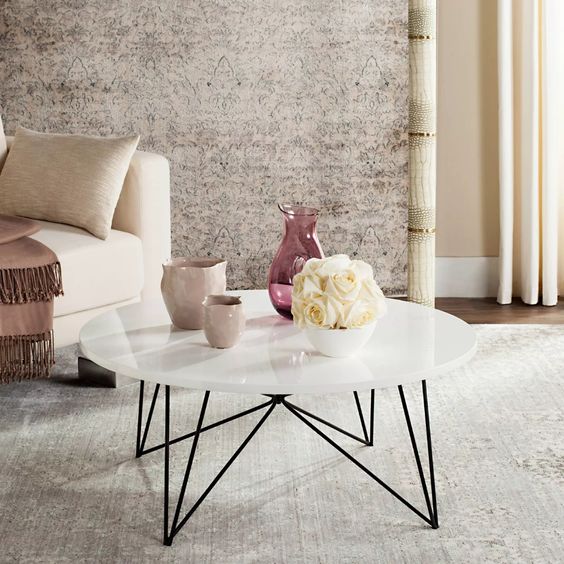 a mid-century modern coffee table with a white round tabletop and black geometric legs is a great idea to rock