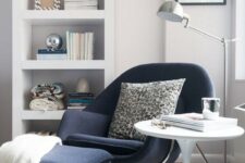 a navy chair and a footrest on tall metal legs inspired by mid-century modern designs