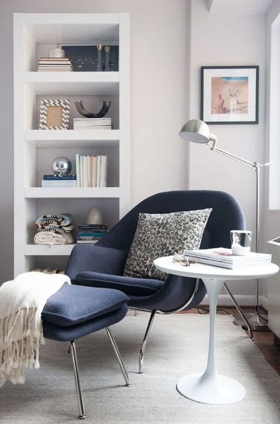 a navy chair and a footrest on tall metal legs inspired by mid-century modern designs