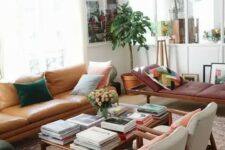 a neutral living room done with warm-colored furniture, with pretty pillows, artworks and potted plants