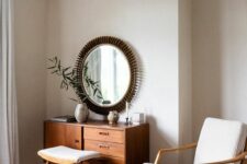 a neutral mid-century modern chair with a light-stained wooden frame, back and legs plus a matching footrest for a modenr bedroom