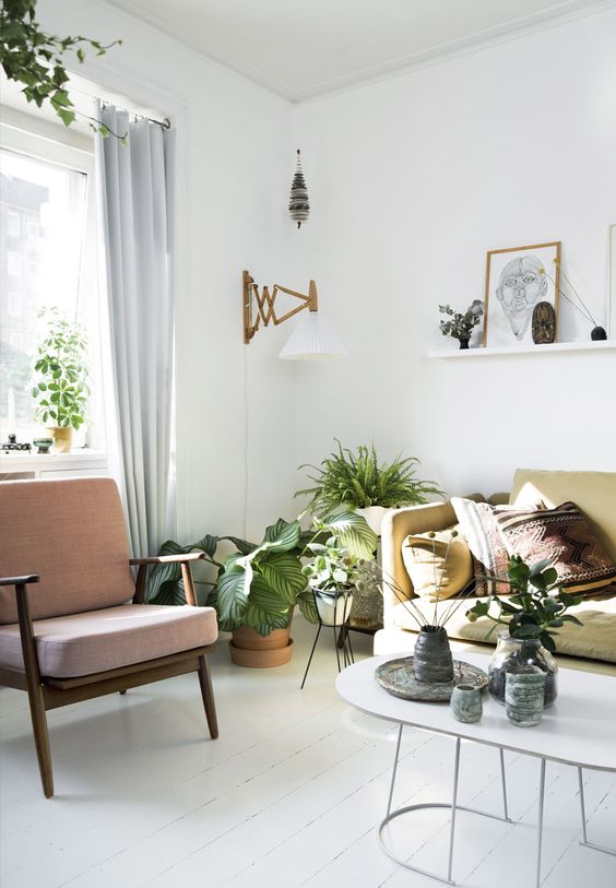 a pastel Scandinavian living room with a yellow sofa and a pink chair with a staiend frame and legs is a cool space