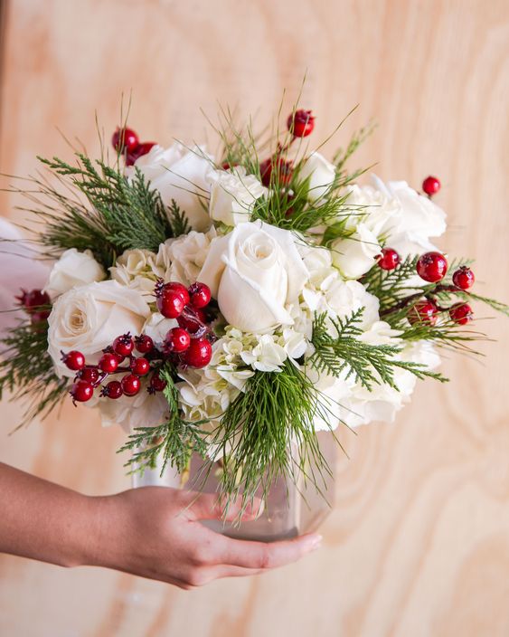 a pretty and simple cranberry Christmas centerpiece of white roses and hydrangeas, greenery and cranberries is a cool idea