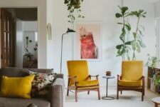 a pretty mid-century modern living room with a grey sofa, mustard chairs and pillows, a colorful rug, potted plants and round tables