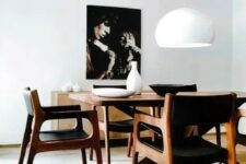a refined yet simple mid-century modern dining space with a stained table and black chairs, a chic credenza and a bold artwork