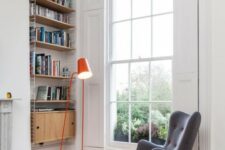 a retro-inspired grey wingback chair with a matching footrest and touches of orange plus a bold orange lamp