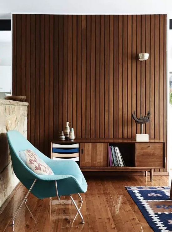 a rich-stained mid-century modern sideboard with doors, colorful drawers and an open storage compartment that matches the stained wall