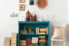 a small teal bookshelf with brown legs will add a bright touch of color to your space