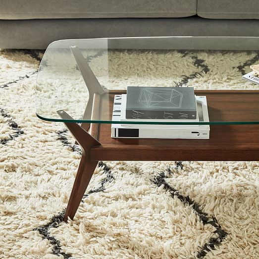 a stylish mid century modern coffee table with a rich stained and a glass tabletop and cool legs is a cool solution for your living room