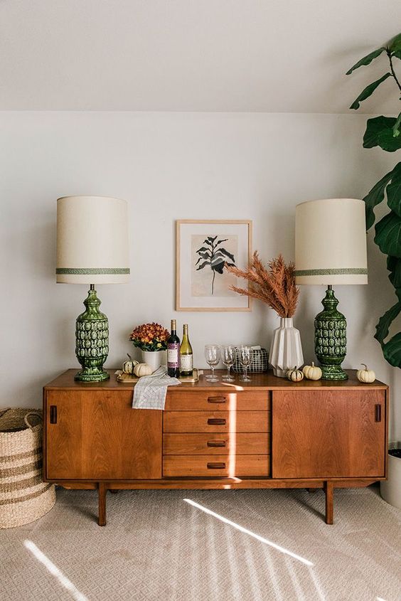 a stylish rich-stained sideboard as a home bar, with sliding doors and drawers with cutout handles is a lovely idea for a mid-century modern space