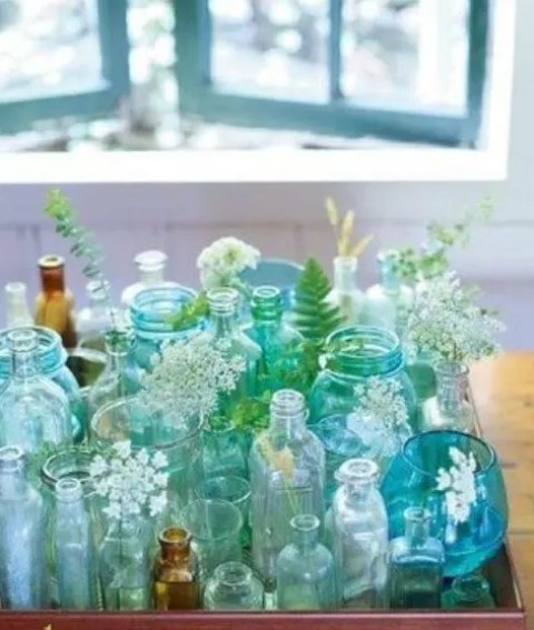 a tray with turquoise and green bottles and vases and some blooms is a lovely decor idea for any space, it's bold and cool and will add interest to your room
