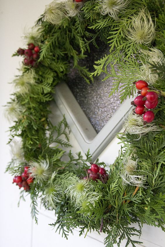 an evergreen and air plant Christmas frame wreath with cranberries is a beautiful and all-natural decor idea for the holidays