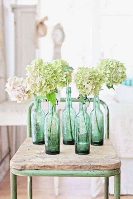 green vintage bottles with blush and green hydrangeas is a cool spring-like decor idea