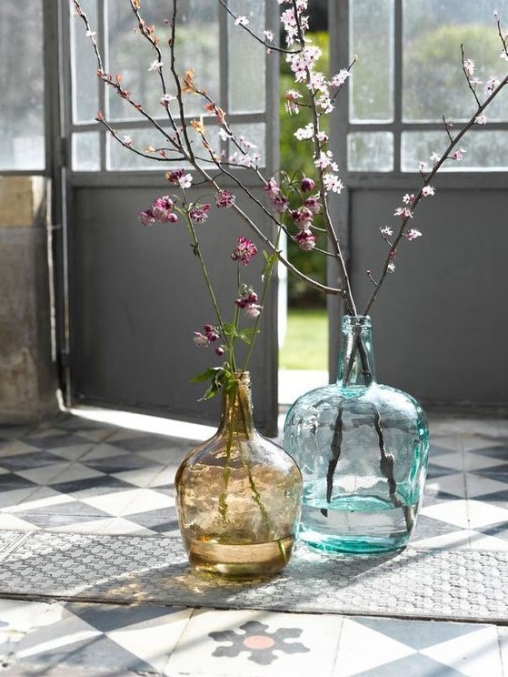 large bottles in blue and brown with blooming branches make the space fresh, bright and spring-filled