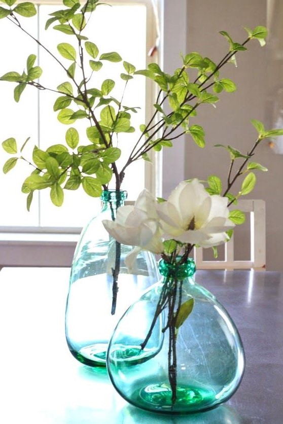 oversized green bottles with leaves and neutral blooms make cool centerpieces and refresh the space