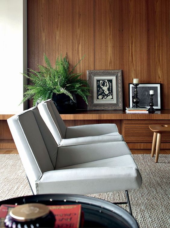 sculptural grey chairs with soft curved armrests are a catchy and bold addition to a mid century modern living room